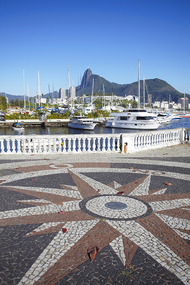 Boats moored in the harbour with Christ the Redeemer statue in background, Urca, Rio de Janeiro, Brazil, South America 