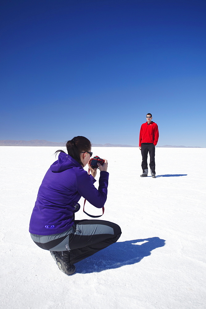 Couple taking photos on Salar de Uyuni (Salt Flats of Uyuni), Potosi Department, Bolivia, South America