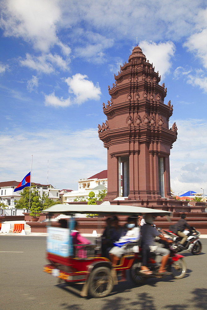 Tuk tuk passing Independence Monument, Phnom Penh, Cambodia, Indochina, Southeast Asia, Asia