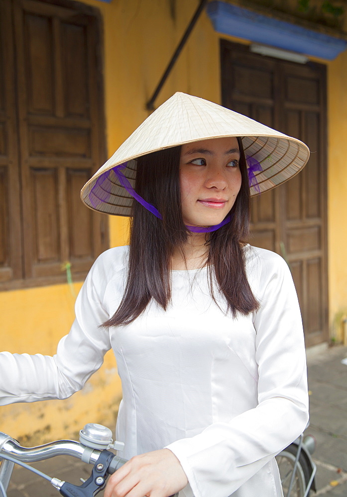 Woman wearing Ao Dai dress with bicycle, Hoi An, Quang Nam, Vietnam, Indochina, Southeast Asia, Asia