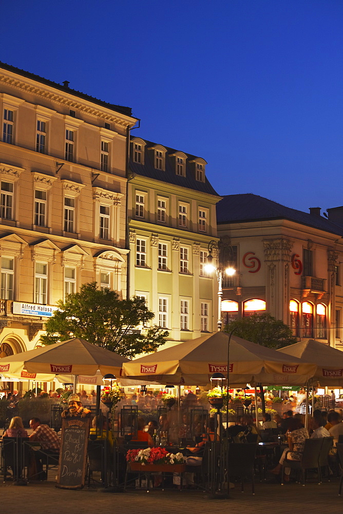 Outdoor cafes in Main Market Square (Rynek Glowny) at dusk, Krakow, Poland, Europe