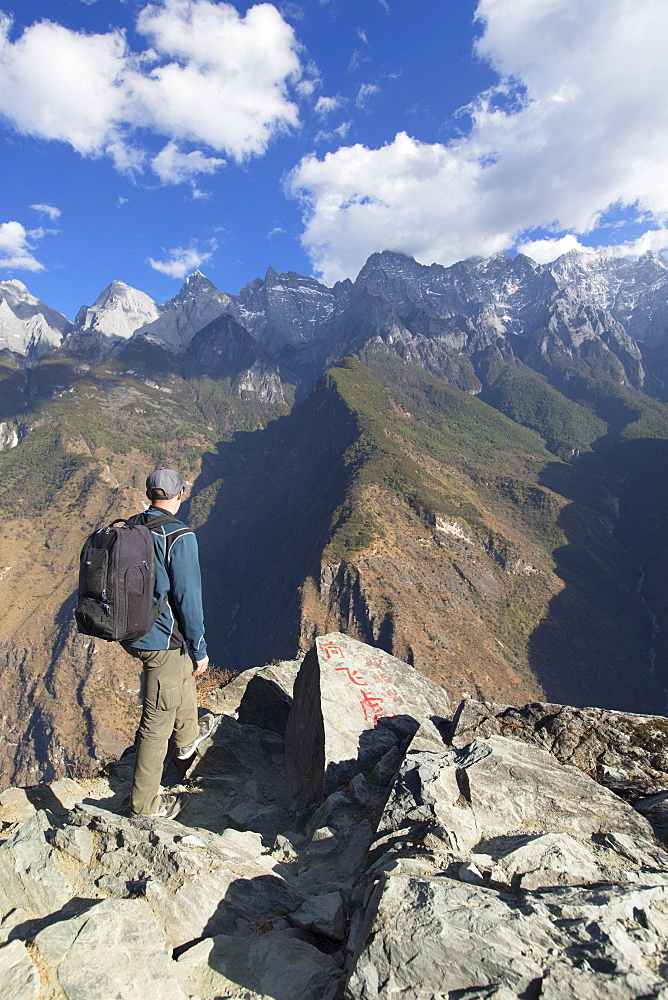 Man hiking in Tiger Leaping Gorge, UNESCO World Heritage Site, with Jade Dragon Snow Mountain (Yulong Xueshan), Yunnan, China, Asia