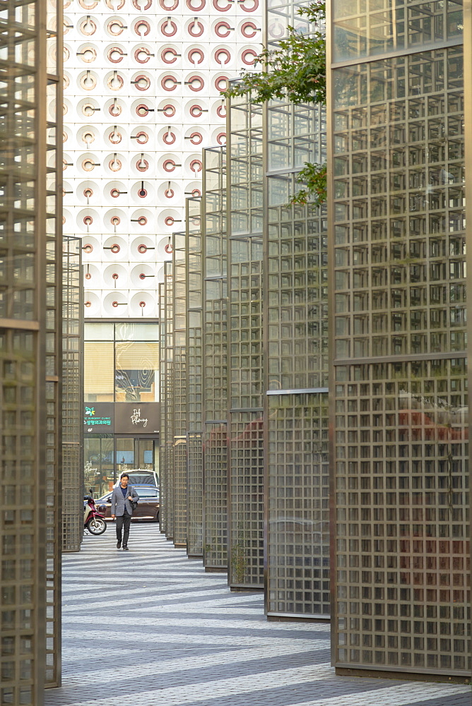 Man walking past modern architecture, Gangnam, Seoul, South Korea, Asia