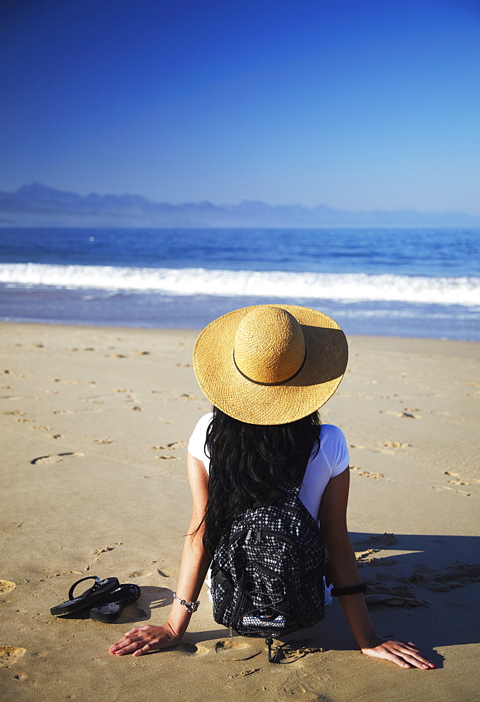 Woman relaxing on beach, Plettenberg Bay, Western Cape, South Africa, Africa