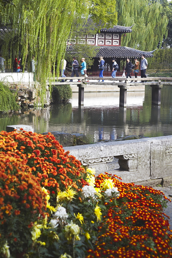 People crossing footbridge in Humble Administrator's Garden, UNESCO World Heritage Site, Suzhou, Jiangsu, China, Asia