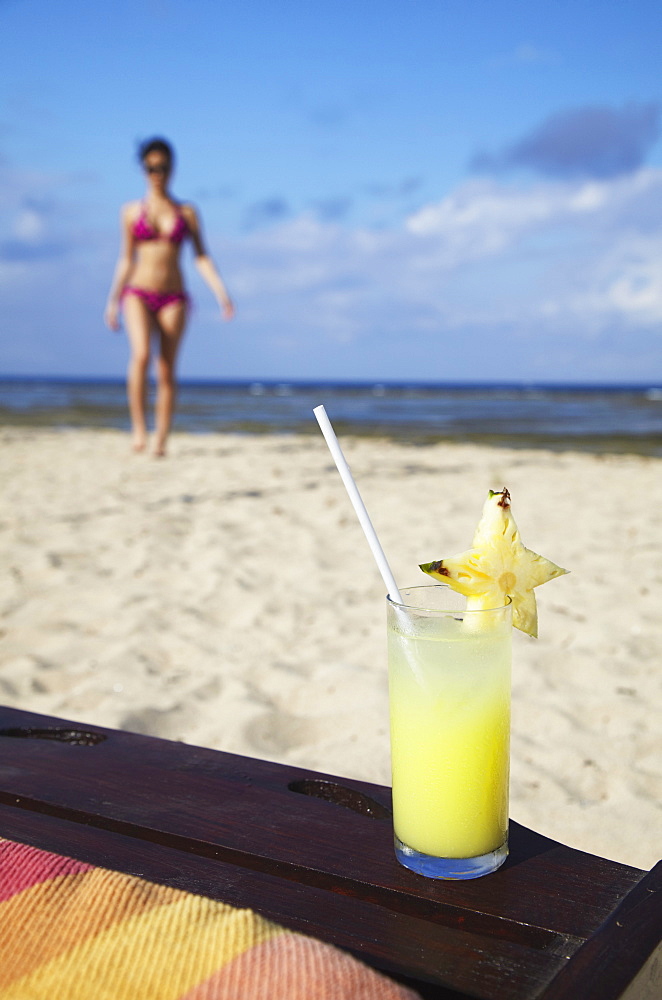 Woman and tropical drink on beach, Sanur, Bali, Indonesia, Southeast Asia, Asia