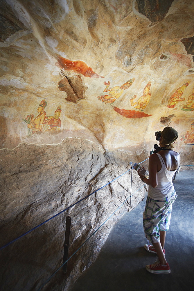 Tourist taking photos of ancient frescoes, Sigiriya, UNESCO World Heritage Site, North Central Province, Sri Lanka, Asia