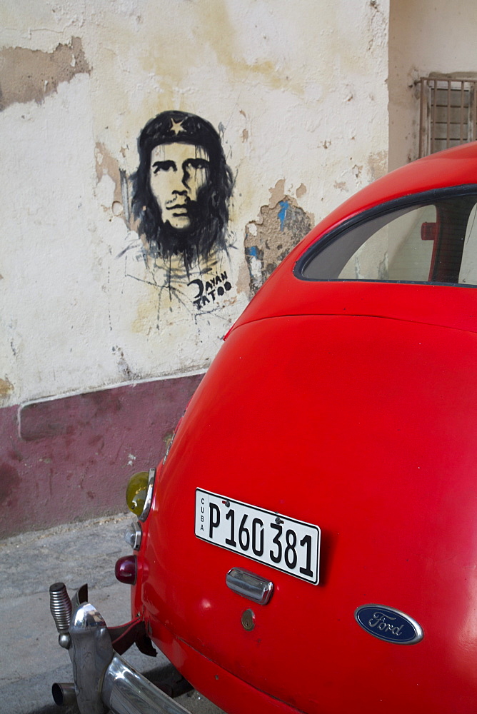 Vintage 1946 Ford with wall mural of Che Guevara, Centro Habana, Havana, Cuba, West Indies, Central America