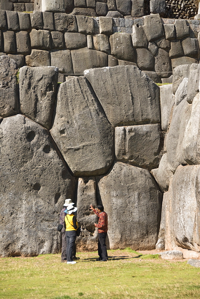 Guide talking to tourists at the Inca fortification of Sacsayhuaman, near Cuzco, Peru, South America