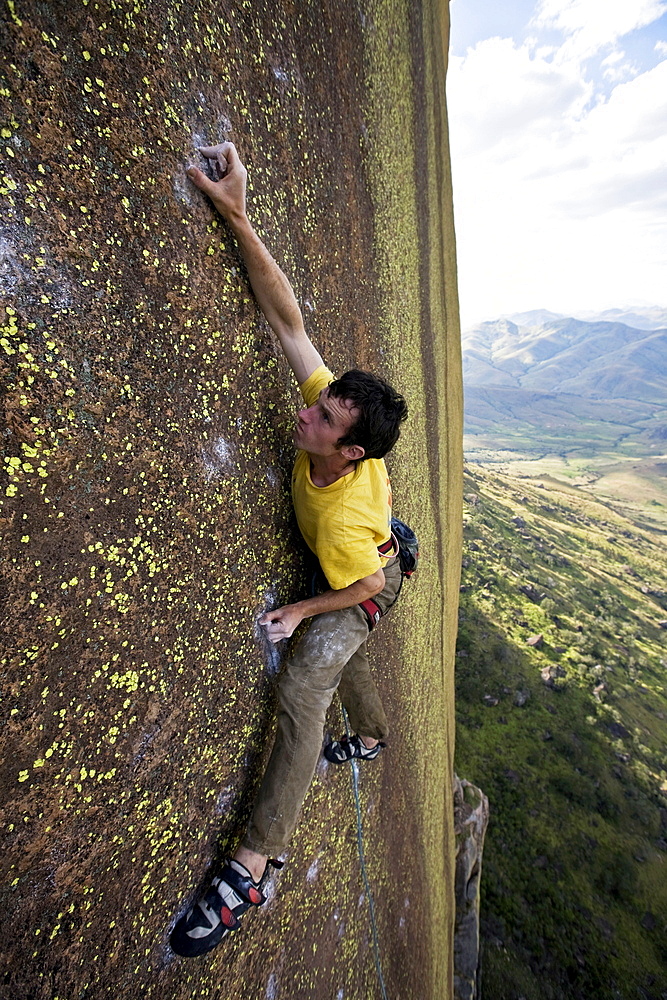 A climber high on the big-wall route on the 450 metre monolith of Karimbony, Tsaranoro Massif, Andringitra National Park, Southern Madagascar, Africa