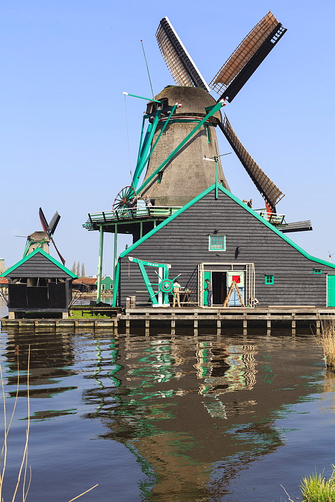 Preserved historic windmills and houses in Zaanse Schans, a village on the banks of the river Zaan, near Amsterdam, it is a popular tourist attraction and working museum, Zaandam, North Holland, Netherlands