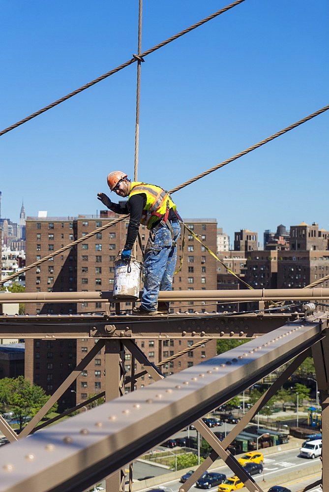 Workman repainting beams and cables on Brooklyn Bridge, New York City, New York, United States of America, North America