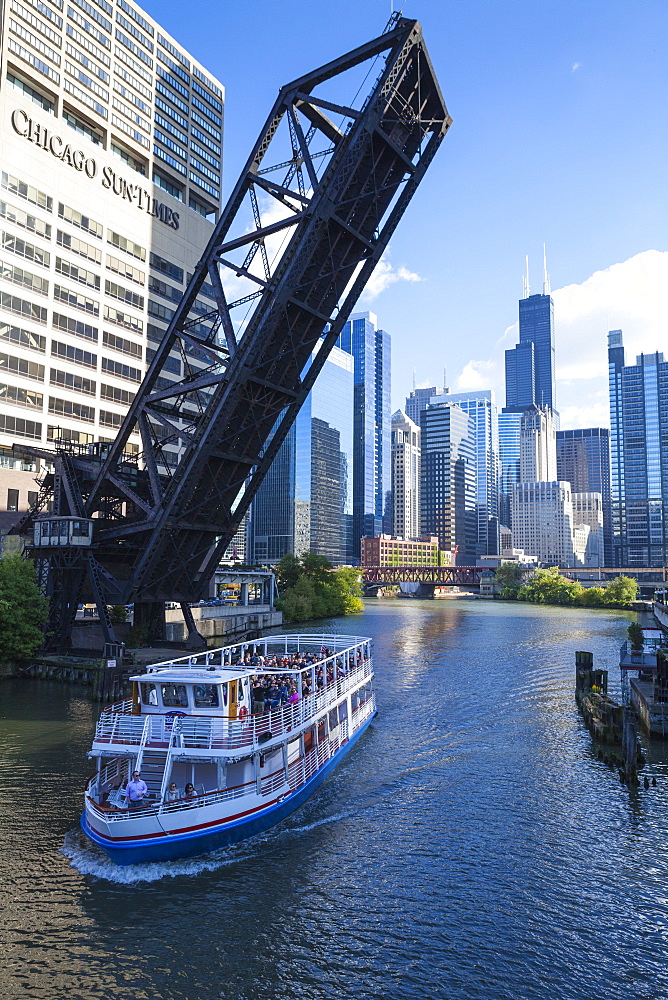 Tour boat passing under a raised disused railway bridge on the Chicago River, Downtown towers in the background, Chicago, Illinois, United States of America, North America