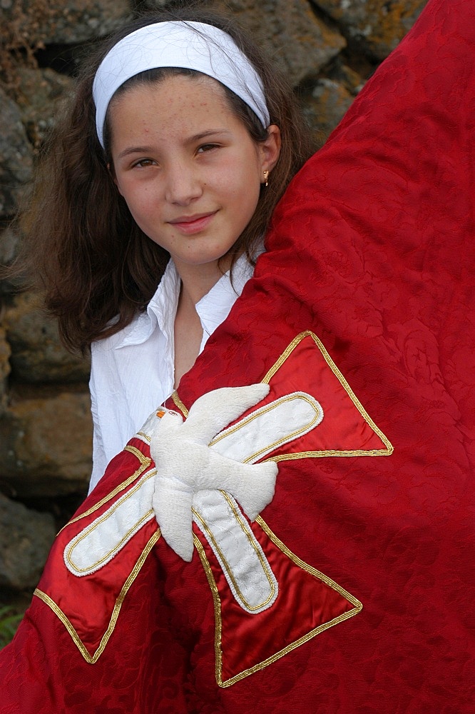 Girl carrying a banner in a Catholic procession during Espiritu Santo Festival in Vila Novo, Terceira, Vila Nova, Azores, Portugal, Europe