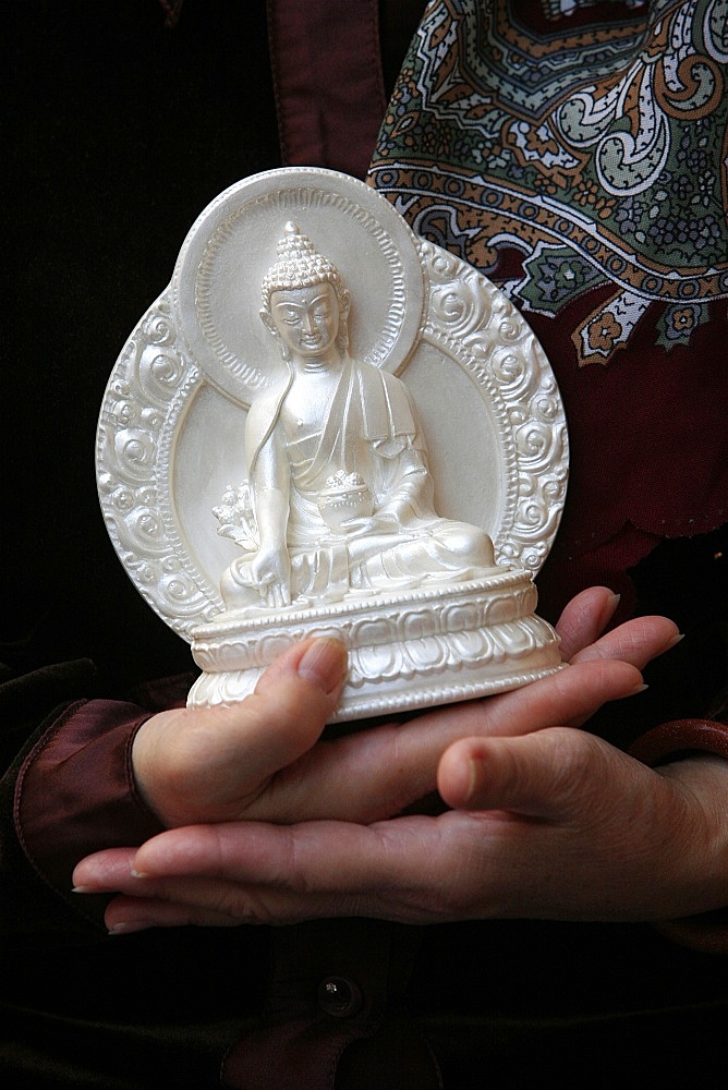 Devotee with Buddha statue, Paris, France, Europe