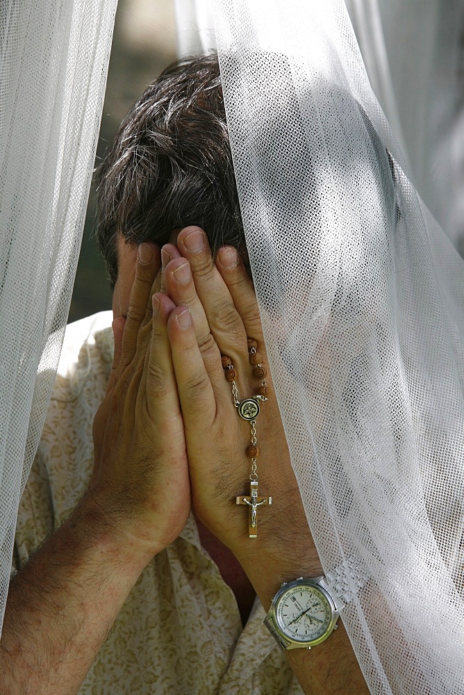 Man praying with rosary, Chatillon-sur-Chalaron, Ain, France, Europe