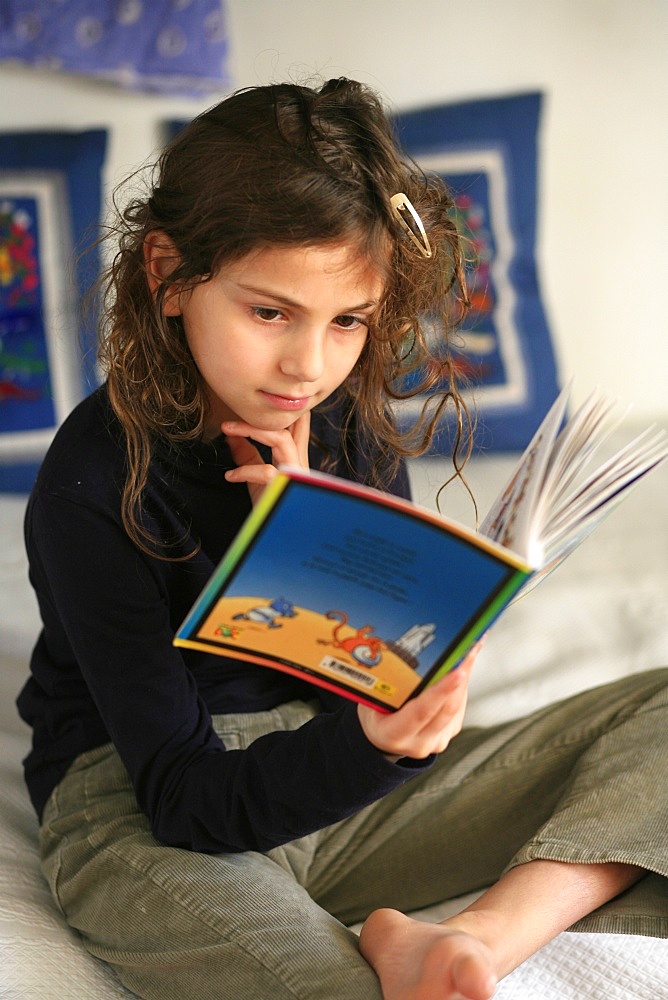 An 8-year old girl reading, France, Europe