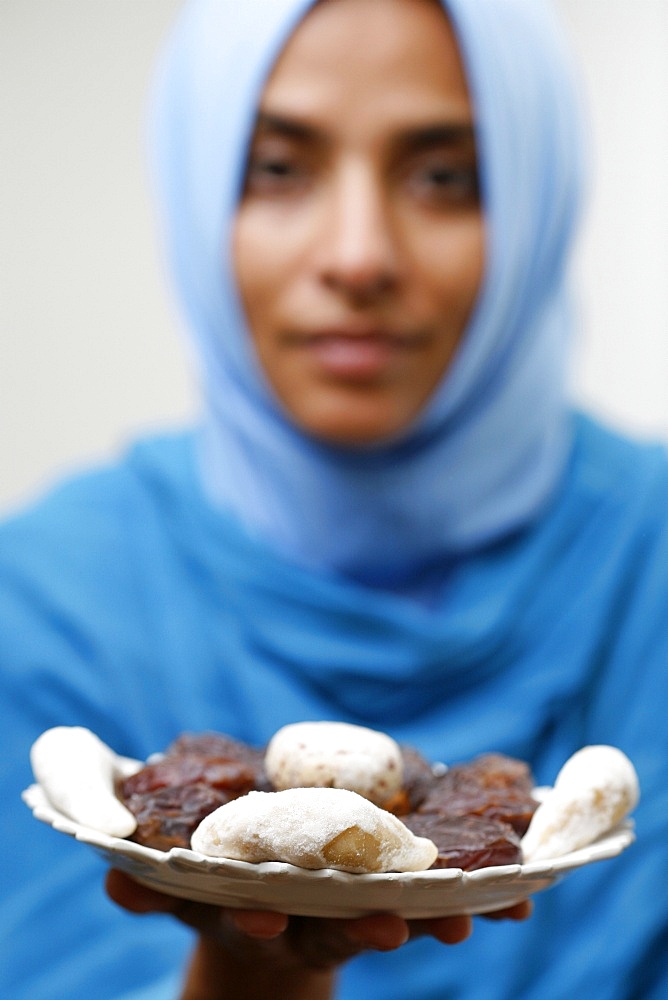 Muslim woman offering Ramadan pastries