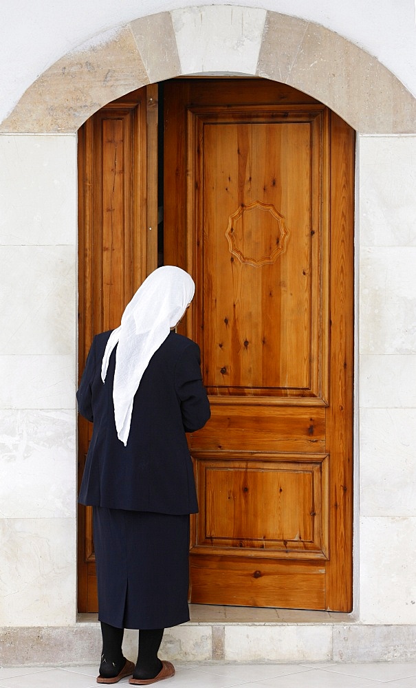 Bektachi woman opening the door of a turbe (shrine with saints' tombs), Elbassan, Albania, Europe