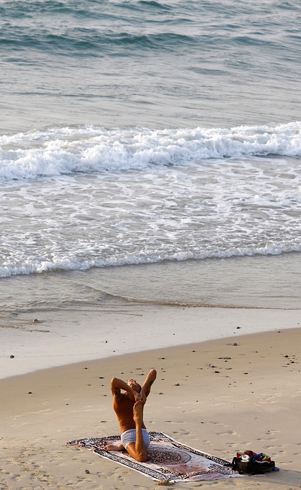 Man doing yoga on Jaffa beach, Jaffa, Israel, Middle East