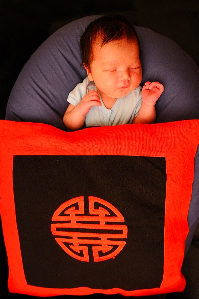 Asian baby with long life symbol, Paris, France, Europe