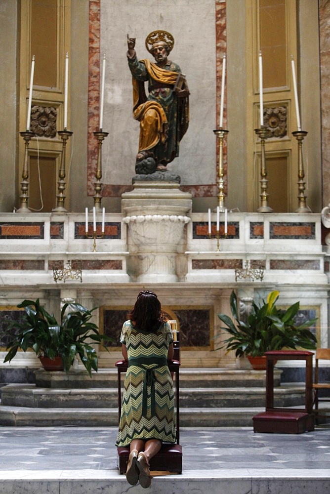 Woman praying to St. Peter in church, Galatina, Lecce, Italy, Europe