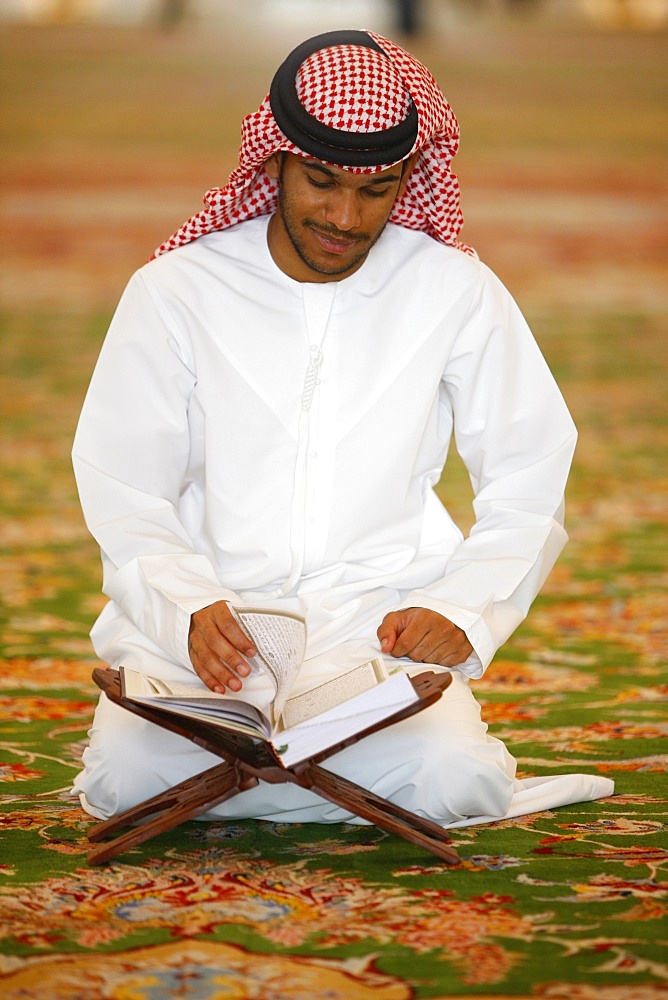 Muslim man reading the Koran, Sheikh Zayed Grand Mosque, Abu Dhabi, United Arab Emirates, Middle East