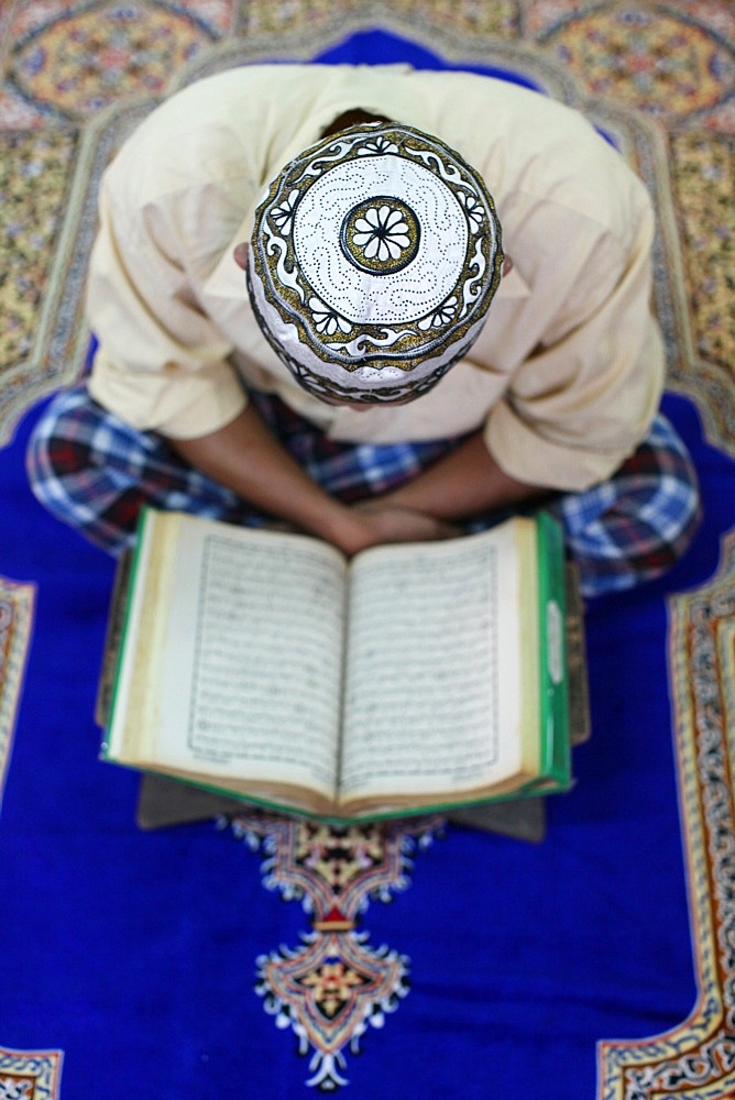 Muslim man reading the Quran in mosque, Ho Chi Minh City, Vietnam, Indochina, Southeast Asia, Asia