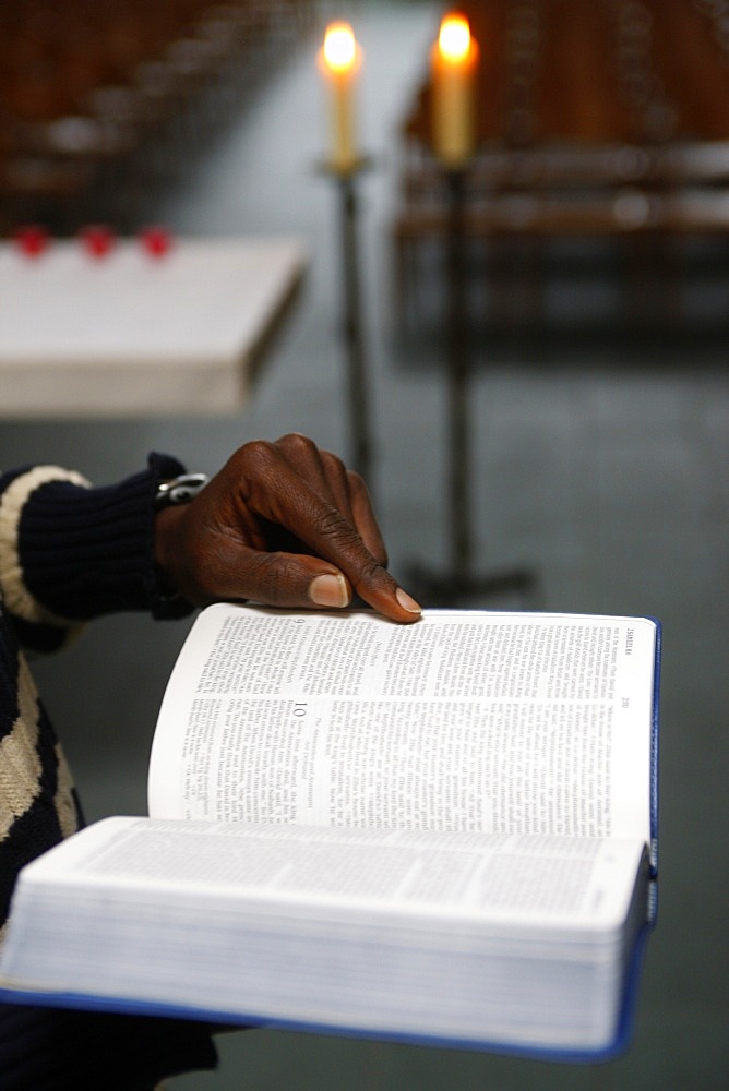 African man reading the Bible in a church, Paris, France, Europe