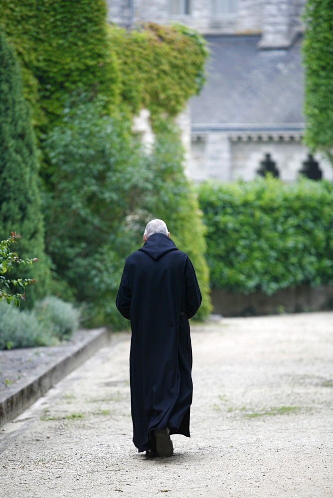 Monk walking in Saint-Pierre de Solesmes Abbey, Solesmes, Sarthe, Pays de la Loire, France, Europe