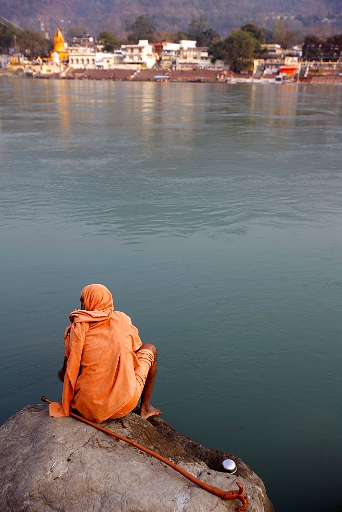 Sadhu sitting by the River Ganges in Rishikesh, Uttarakhand, India, Asia