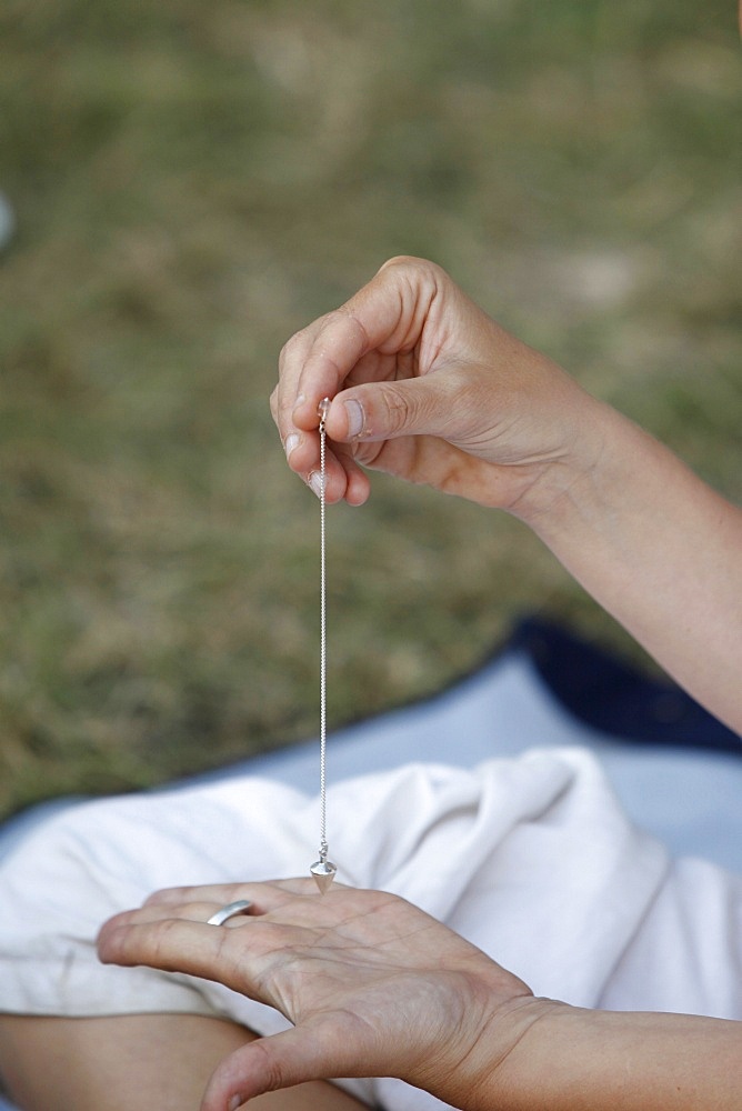 Woman using a pendulum at a Kundalini Yoga festival, Mur-de-Sologne, Loir-et-Cher, France, Europe