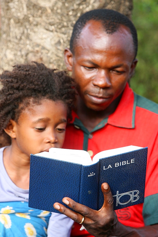 Father and daughter reading the Bible, Lome, Togo, West Africa, Africa