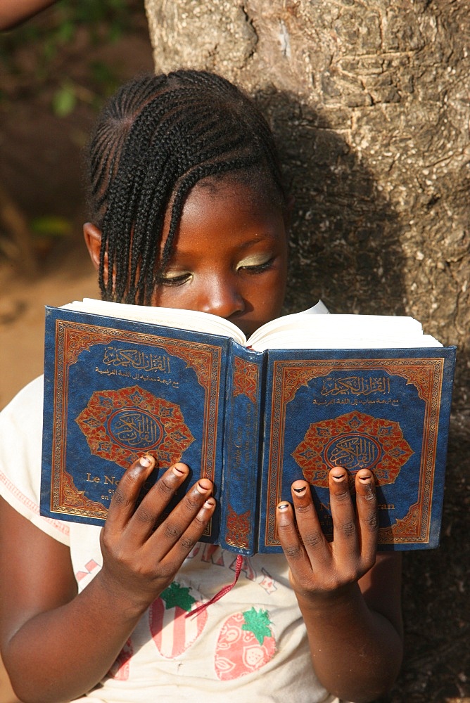 Young girl reading the Koran, Lome, Togo, West Africa, Africa