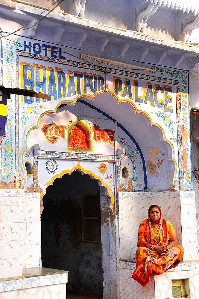 Woman in front of an old temple transformed into an hotel, Pushkar, Rajasthan, India, Asia