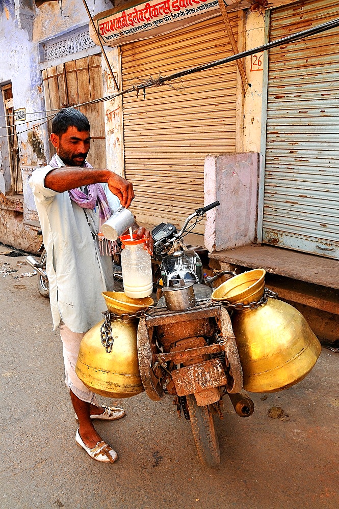 Milk collector carrying milk-churns on his motorbike, Pushkar, Rajasthan, India, Asia