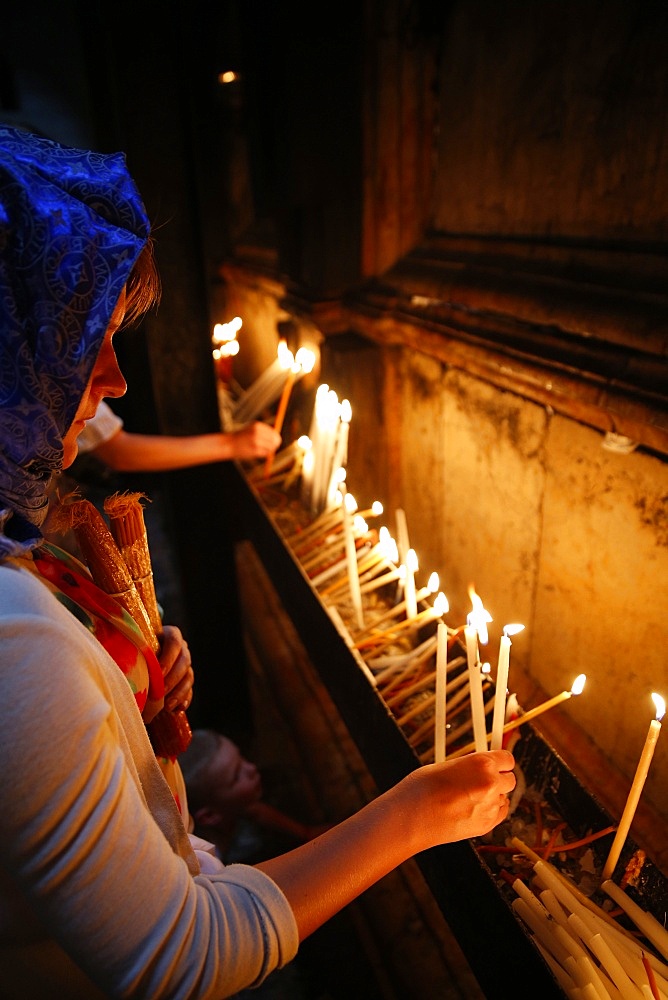 Pilgrims lighting candles in the Holy Sepulchre Church, Jerusalem, Israel, Middle East