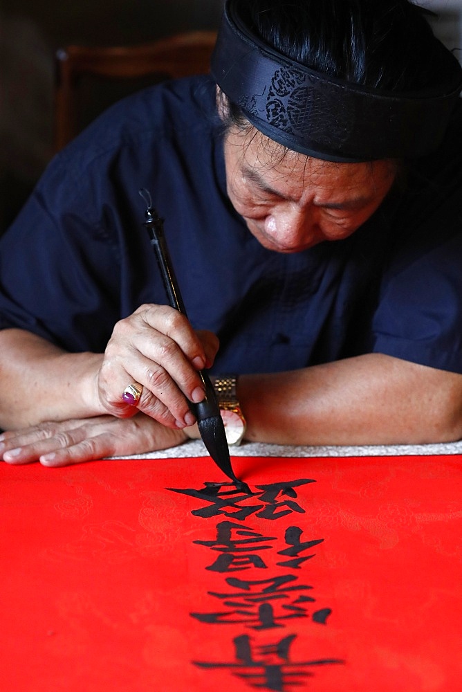 Man doing traditional Chinese writing (calligraphy) in ink using a brush, The Temple of Literature, Hanoi, Vietnam, Indochina, Southeast Asia, Asia