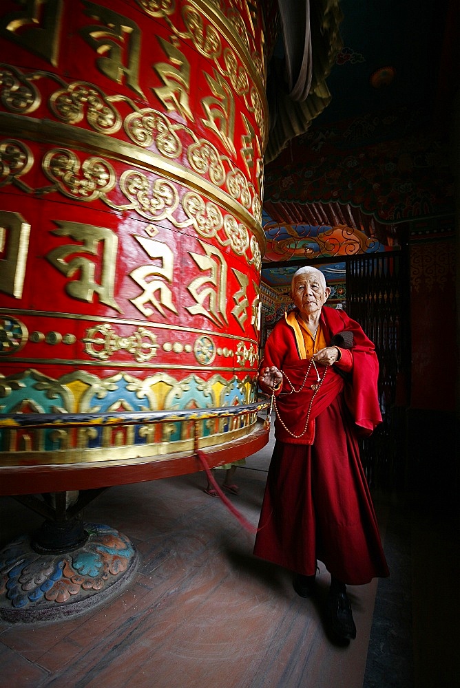 Woman and prayer wheel, Bodhnath Stupa, Kathmandu, Nepal, Asia