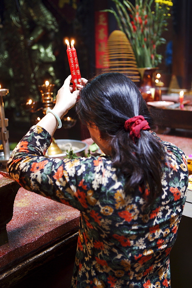 Local woman making an offering in a Buddhist temple, Ho Chi Minh City, Vietnam, Indochina, Southeast Asia, Asia