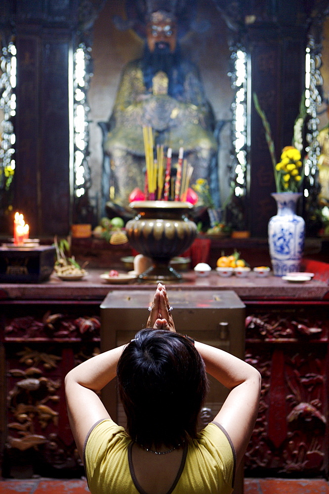 Local woman praying and meditating in front of offerings in Buddhist temple, Ho Chi Min City, Vietnam, Indochina, Southeast Asia, Asia