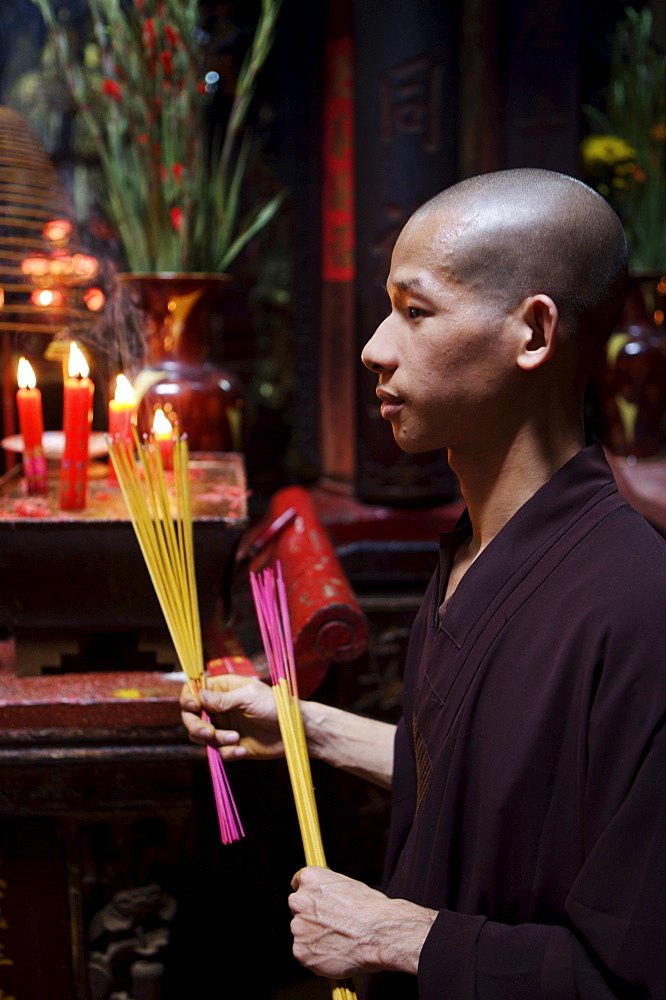 Monk with joss sticks during ceremony in a Buddhist temple, Ho Chi Min City, Vietnam, Indochina, Southeast Asia, Asia