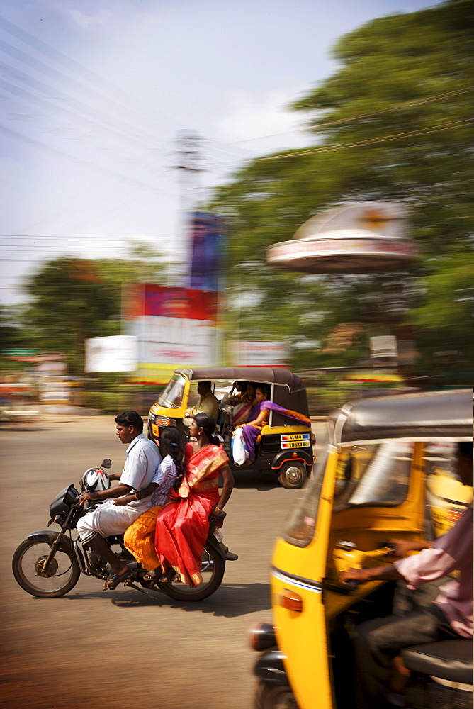 Traffic with colourful locals on motorbikes and tuk tuks, Kerala, India, Asia