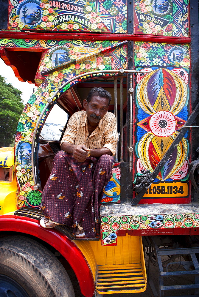 Kerelan driver sitting in cab of brightly decorated lorry, Kerala, India, Asia