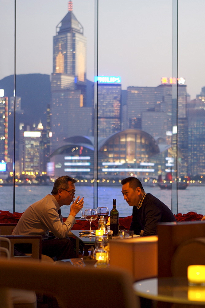 Businessmen drinking in hotel bar at dusk, Hong Kong, China, Asia