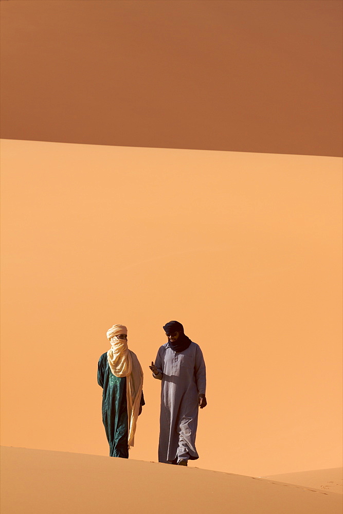 Two Tuaregs in the dunes of the erg of Murzuk in the Fezzan desert, Libya, North Africa, Africa