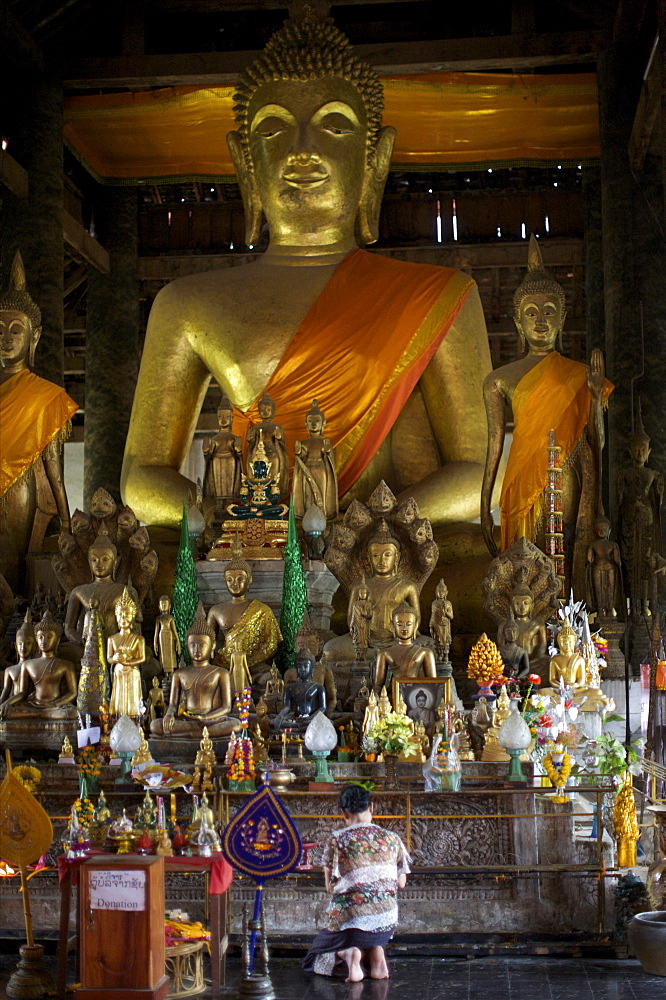 Woman praying in front of the Buddha in Luang Prabang Royal Palace temple, Luang Prabang, Laos, Indochina, Southeast Asia, Asia