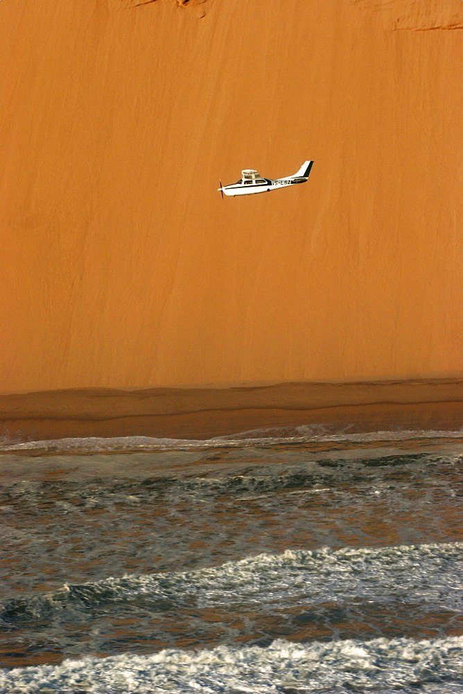 A small Cessna flying between the ocean and the desert, Skeleton Coast, Namibia, Africa