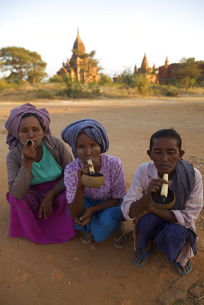 Three women smoking some Burmese cigars at Bagan, Myanmar, Asia