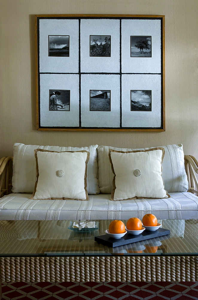 Cream sofa and cushions, under six photographs in one frame in villa, Baie aux Tortues, Pointe aux Pimentes, Mauritius, Africa